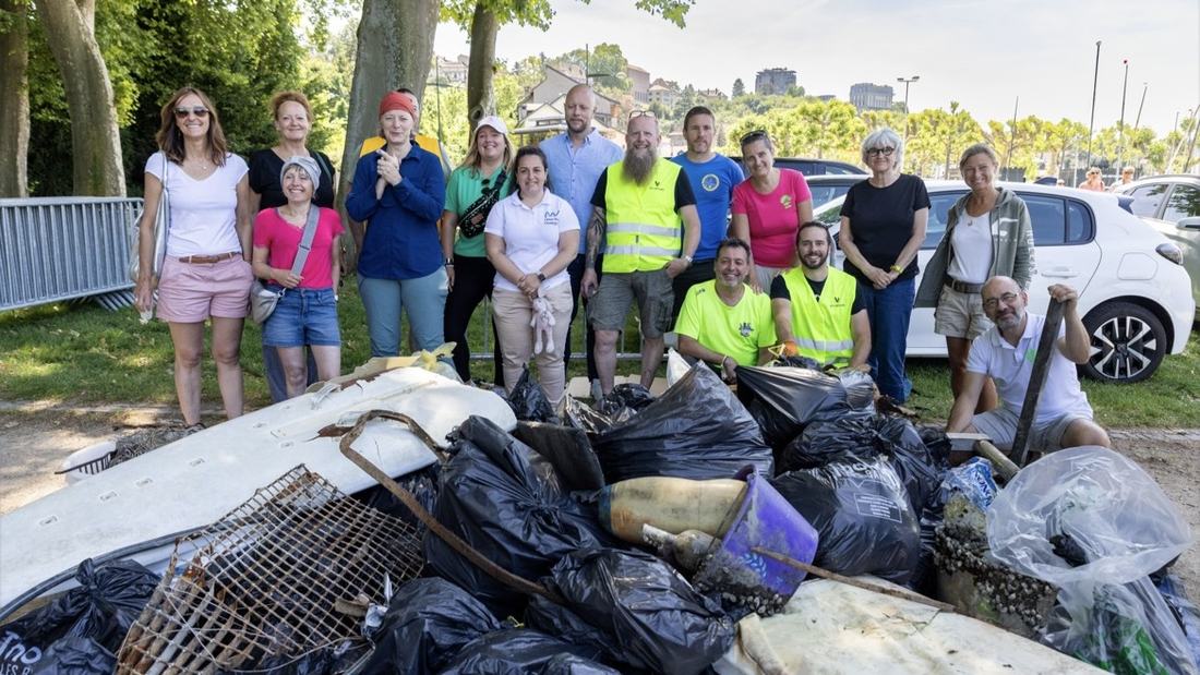 Bénévoles réunis derrière les sacs et les encombrants sortis de l’eau