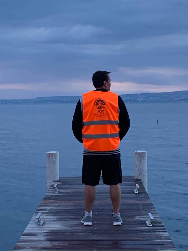 Le fondateur de l’association, en gilet, sur un ponton face au Léman